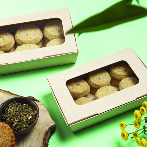 green background, cardboard boxes fulfilled with biscuits