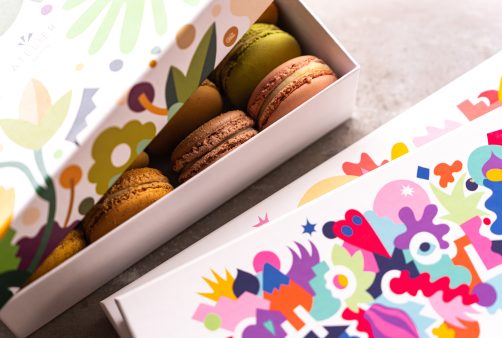 Some macarons in colorful cardboard boxes