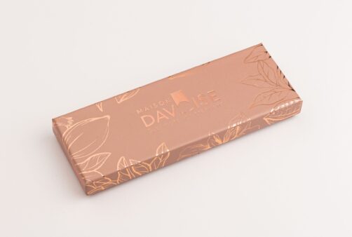 Réglette de chocolats Maison Davoise couleur cuivre avec motifs floraux embossés, fermée sur fond clair.