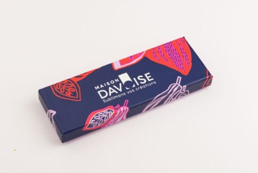 Réglette de chocolats Maison Davoise bleu nuit décorée de cabosses colorées, fermée sur fond clair.